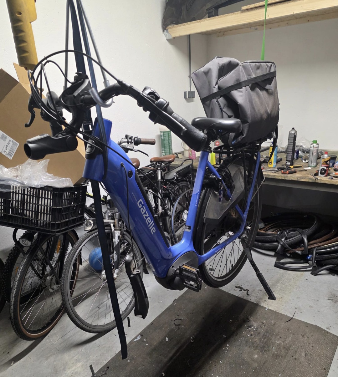 Een e-bike opgehangen in de werkplaats, klaar voor onderhoud